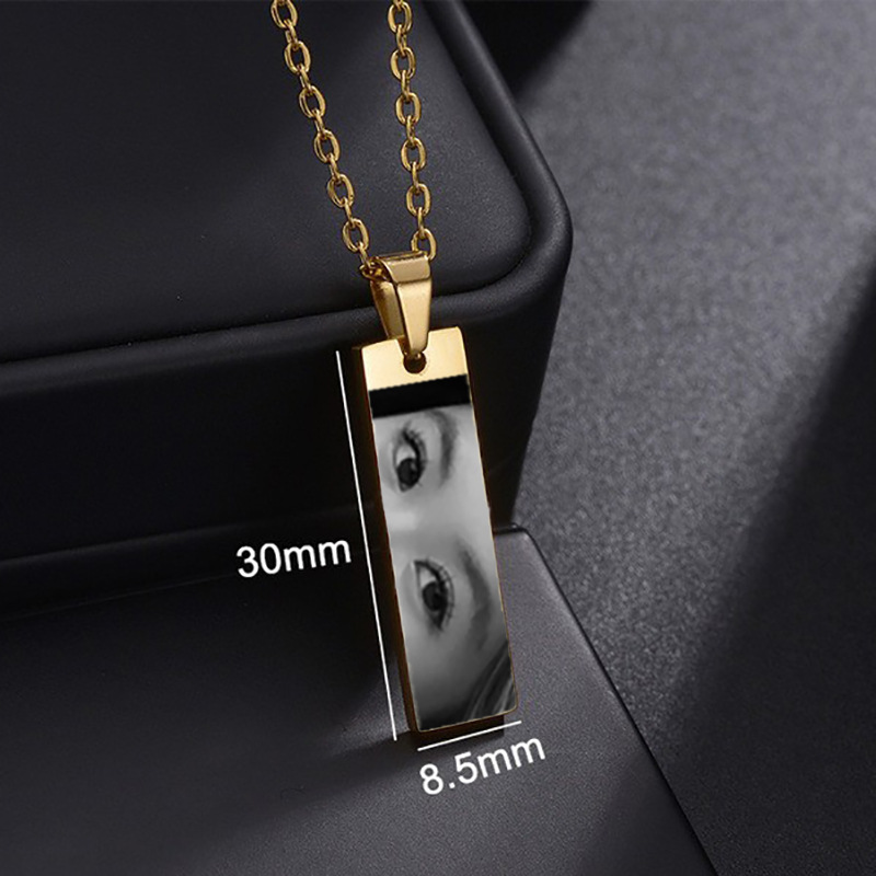 Close-up of laser engraving on a gold bar pendant